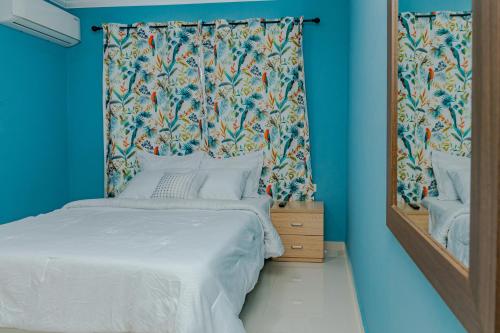 a bedroom with a bed with a curtain and a mirror at SPECIAL OFFER !! 7 min to Beach - Newly-Renovated Modern Luxury Home in Paradera