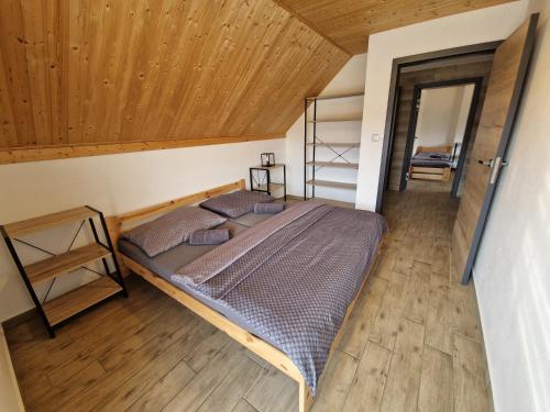 a bedroom with a bed and a wooden ceiling at Relax Vila Lipno 2 u pláže Windy Point in Černá v Pošumaví
