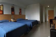 a hotel room with two beds and a desk at Hotel CEO in Morelia