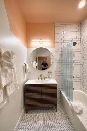 a bathroom with a sink and a mirror and a tub at Peninsula Bed & Cocktails in St Petersburg