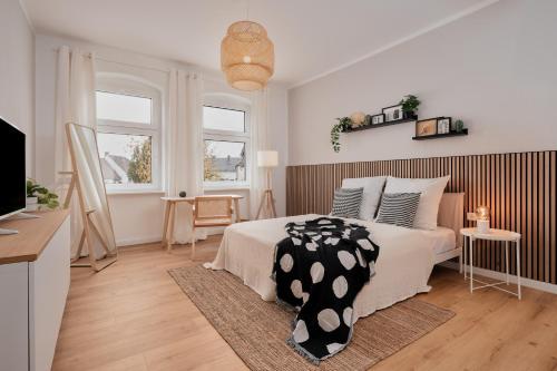 Jugendstil-Altbauwohnung an der Karlsaue - 120qm, Klimaanlage, neu saniert, zentrale Lage في كاسيل: غرفة نوم بها سرير كبير وتلفزيون