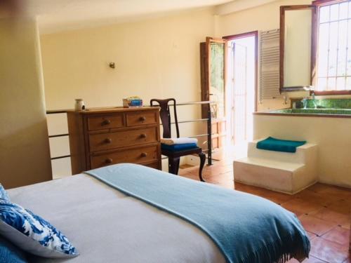 ein Schlafzimmer mit einem Bett, einer Kommode und einem Fenster in der Unterkunft Casa Azahar in Saleres