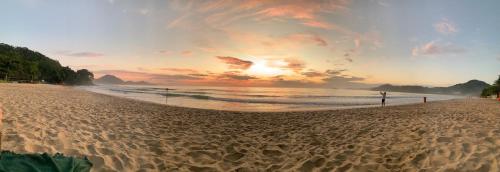 a view of a beach with a sunset at Canto das Toninhas Guest House in Ubatuba