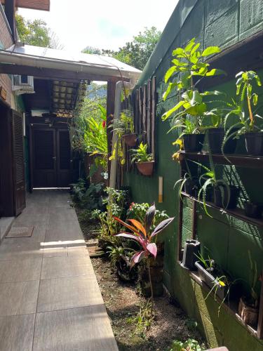 a garden with plants on the side of a building at Canto das Toninhas Guest House in Ubatuba