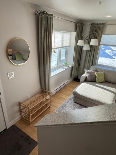 a living room with a couch and a mirror at DWELL in Alaska Apartment b in Fairbanks