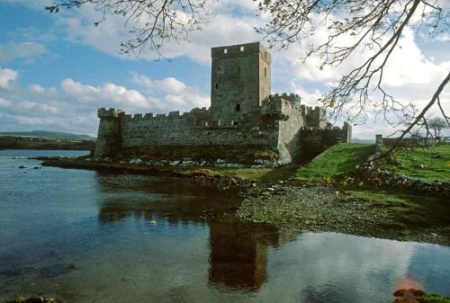 a castle sitting on the edge of a body of water at Town House Creeslough in Creeslough