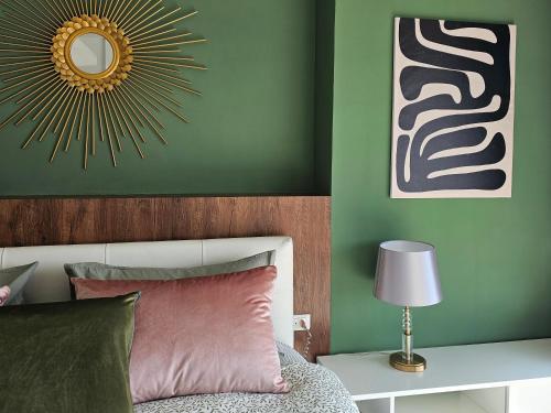 a bedroom with green walls and a bed with a mirror at Patong Tower Apartment Family Room See View in Patong Beach