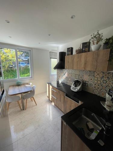 - une cuisine avec un évier et une table dans une chambre dans l'établissement Loretto proche centre ville et plage, à Ajaccio