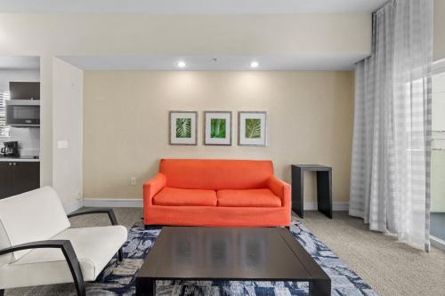 a living room with an orange couch and a table at Provident Doral At The Blue in Miami