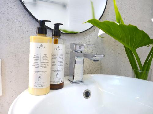 two bottles ofodorizers sitting on a bathroom sink at Apartment Sweet Pear with garage in Armação de Pêra