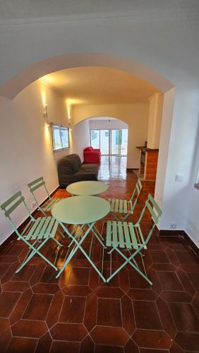 a living room with a table and chairs and a couch at CARCAROOMS Guest House in Carcavelos