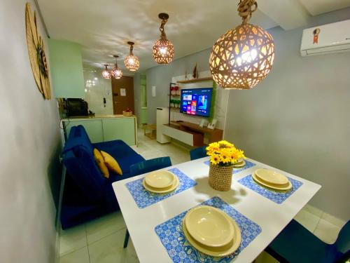 a kitchen and living room with a table and chairs at Flat premium centro de Porto de Galinhas-Makambira Residence-Flat309 in Porto De Galinhas