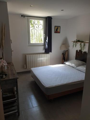 une chambre avec un grand lit et une fenêtre dans l'établissement Maison de campagne, à Saint-Hilaire-de-Brethmas