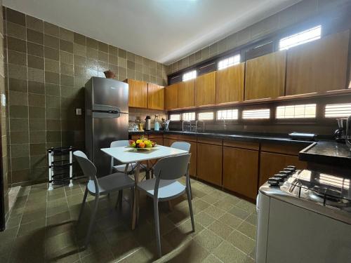 a kitchen with a white table and a refrigerator at Studio Sol - 3 min do Mossoró Cidade Junina in Mossoró