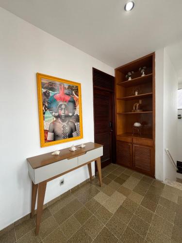 a room with a desk and a painting on the wall at Studio Sol - 3 min do Mossoró Cidade Junina in Mossoró