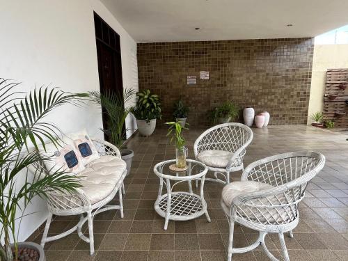 a patio with chairs and a table and some plants at Studio Sol - 3 min do Mossoró Cidade Junina in Mossoró