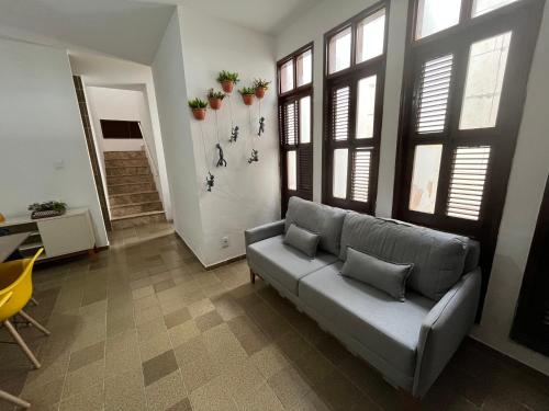 a living room with a couch and some windows at Studio Sol - 3 min do Mossoró Cidade Junina in Mossoró