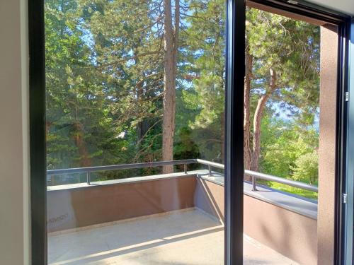 a window with a view of a bath tub on a balcony at Terase Zlatibor apartmant 115 in Zlatibor