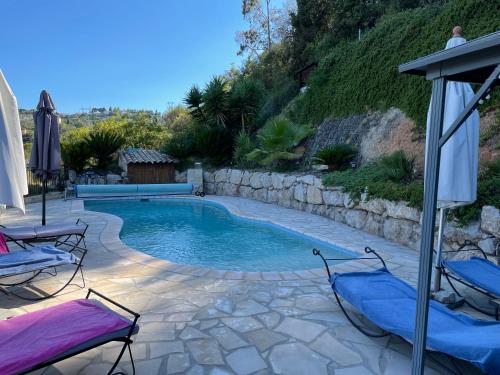 une piscine avec deux chaises et un parasol dans l'établissement Beautiful villa Nice, à Nice