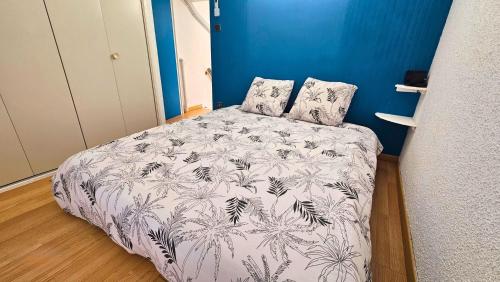 une chambre avec un lit avec une couverture noire et blanche dans l'établissement Maisonnette à 150m de la plage, climatisée, 6 couchages, au Barcarès