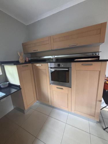 a kitchen with wooden cabinets and an oven at Lucia's place in Pretoria