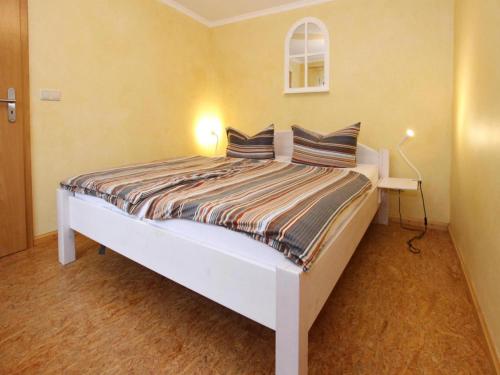 a bedroom with a white bed with two pillows at Ferienhaus in der Feldberger Seenlandschaft in Wrechen