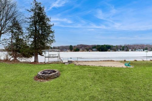 a fire pit in the grass next to a lake at The Four Seasons on The Torch Chain in Bellaire