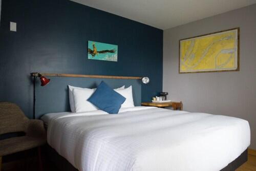 a bedroom with a large bed with a blue wall at Salt Hotel & Pub in Ilwaco