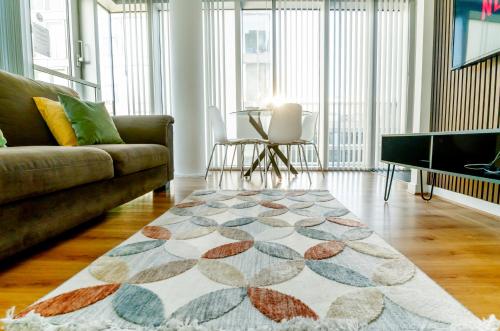 a living room with a couch and a rug at Luxury Two Bed City Apartment -The Hub in Milton Keynes