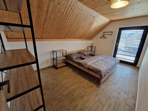 a bedroom with a bed and a wooden ceiling at Relax Vila Lipno 2 u pláže Windy Point in Černá v Pošumaví