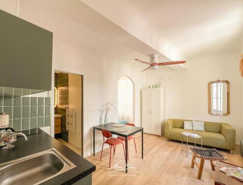 une cuisine et un salon avec une table et un canapé dans l'établissement Le Nid Provençal - Vue Cathédrale - 300 metres du port, à Toulon