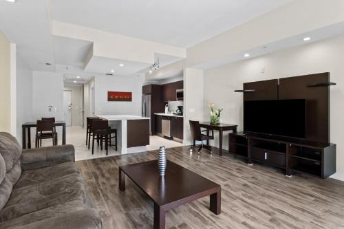 a living room with a couch and a tv and a table at Provident Doral At The Blue in Miami