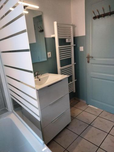 une salle de bain avec un lavabo et un miroir dans l'établissement L'Oasis Urbain, à Dunkerque