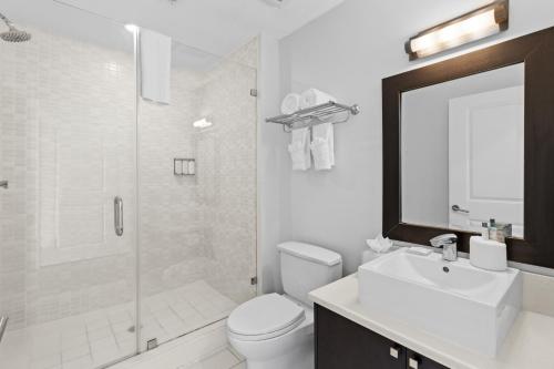a bathroom with a toilet and a sink and a shower at Provident Doral At The Blue in Miami