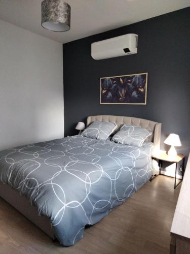 une chambre avec un lit avec une couette bleue dans l'établissement L'Oasis Urbain, à Dunkerque