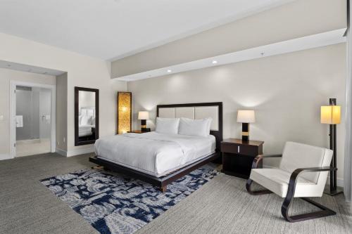 a bedroom with a white bed and a chair at Provident Doral At The Blue in Miami