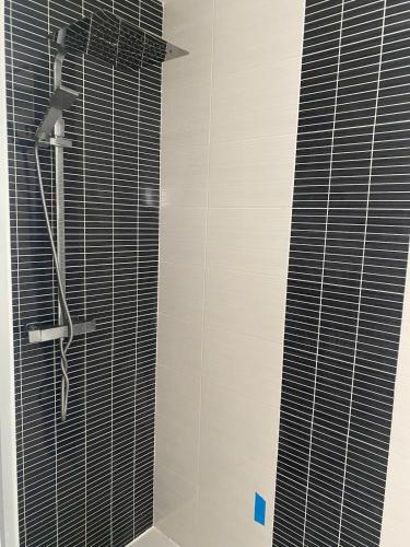 a bathroom with a shower with black and white tiles at Maison Cieurac in Cieurac