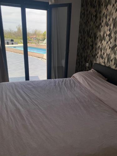a bedroom with a bed and a view of a pool at Maison Cieurac in Cieurac