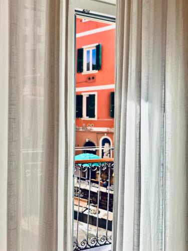 a view of a building through a window with curtains at La Ripa Camere Vernazza - La Medusa Studio in Vernazza