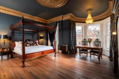 a bedroom with a canopy bed and a desk at The Harrison Chambers of Distinction in Belfast