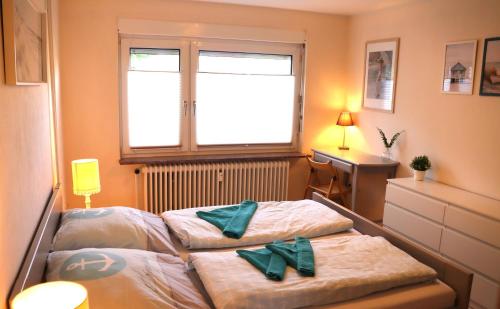 zwei Betten in einem kleinen Zimmer mit Fenster in der Unterkunft Ferienwohnung Borkum in Holtgast