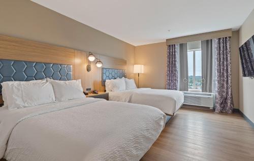 a hotel room with two beds and a window at Candlewood Suites Perry-National Fairground Area by IHG in Perry