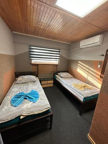 two beds in a room with a blue bow at Zajazd Restauracja Derby in Błonie
