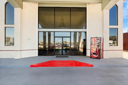 a red rug in front of a building with a glass door at Red Roof Inn Stafford, TX in Stafford