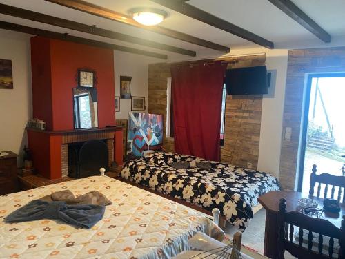 a bedroom with two beds and a fireplace and a clock at To σαλέ της λίμνης 2 in Kalyvia Fylaktis