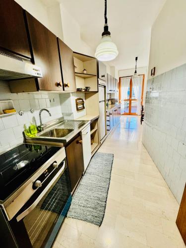 a kitchen with a sink and a stove top oven at Nido tra monti in Sondrio