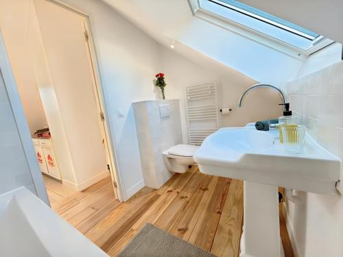une salle de bain blanche avec un lavabo et des toilettes dans l'établissement HérouVillers - Bright duplex in Hypercentre & Beach a stone's throw away, à Villers-sur-Mer