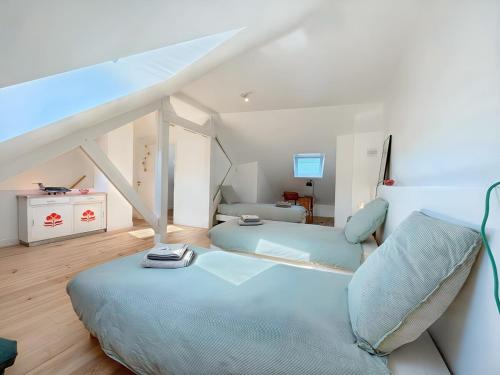 - une chambre mansardée avec 2 lits et un canapé dans l'établissement HérouVillers - Bright duplex in Hypercentre & Beach a stone's throw away, à Villers-sur-Mer