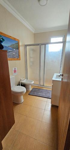 a bathroom with two toilets and a glass shower at Santa Barbara Beach hotspot in Ribeira Grande