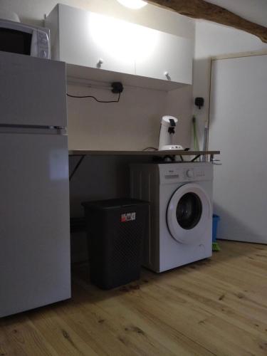 une cuisine avec un réfrigérateur et une machine à laver dans l'établissement Chez Amandine, à Molières